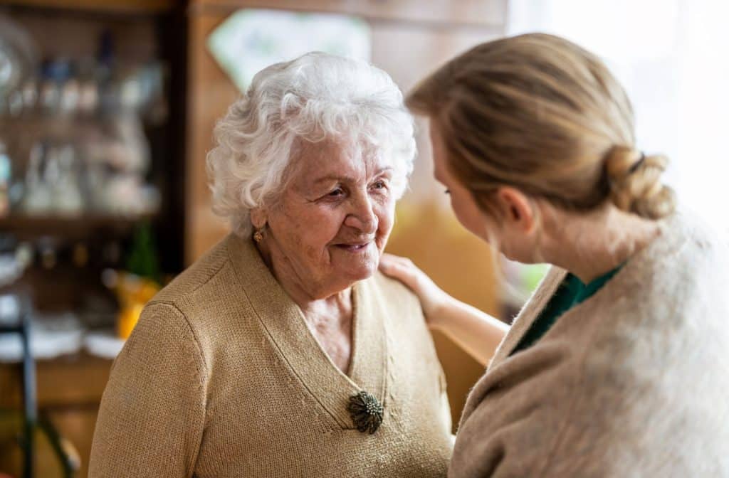 Young woman visiting her elderly relative in memory care.