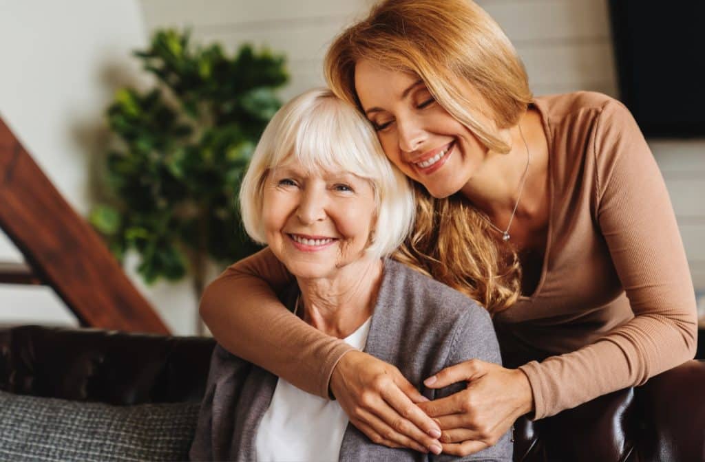 A daughter happily hugs her mother in memory care.