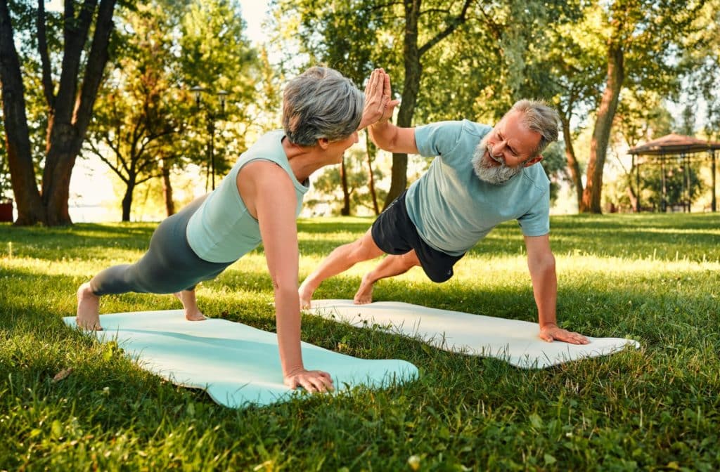 A mature couple enjoys exercising together outside on a beautiful sunny day.