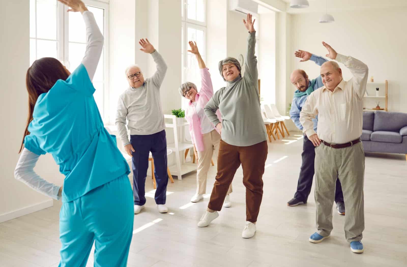 A group of residents in assisted living enjoy participating in group fitness activities.